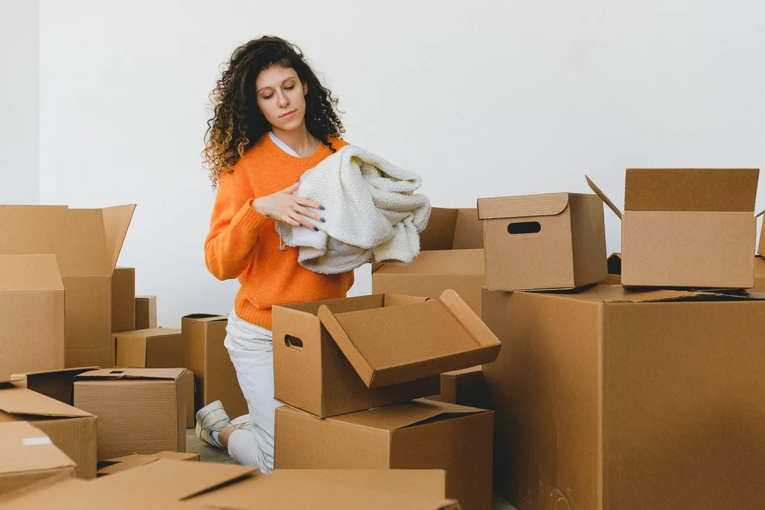 Frau packt Kartons in einer Wohnung